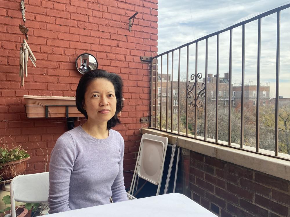 Beata Moon sits on the balcony of her Queens, New York, apartment on Dec. 9. Because she is not fully vaccinated, much of New York City is off-limits to her.