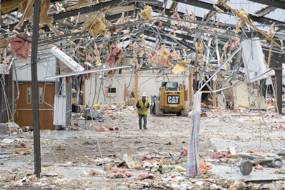 A worker walks through a destroyed Baptist Health Deaconess Medical Group building in Dawson Springs.