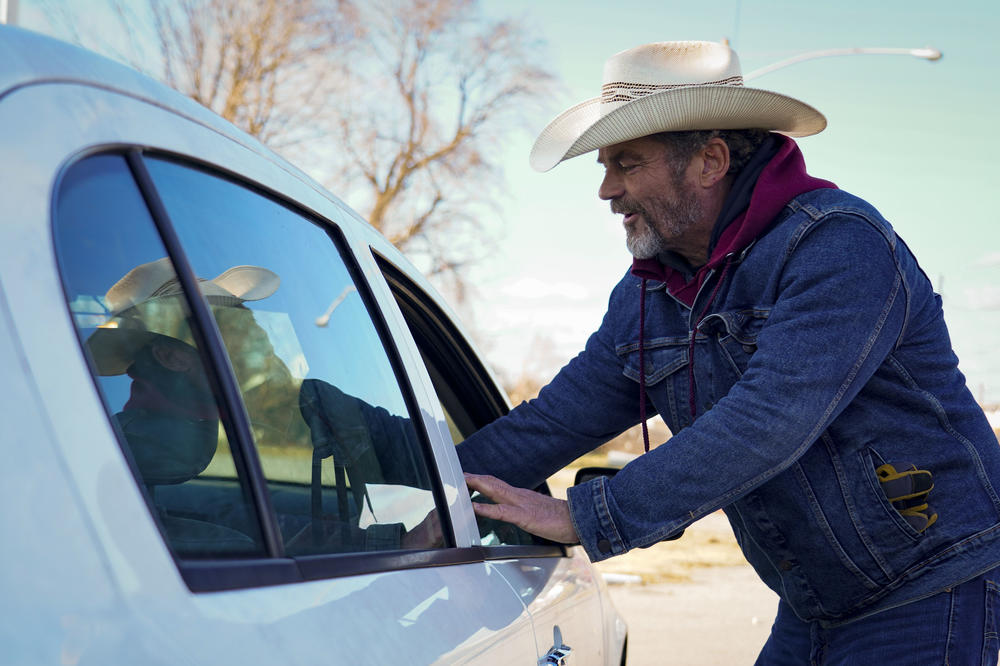 Dave 'Cowboy' Graham speaks with the driver of a passing vehicle in Dawson Springs, Kentucky.