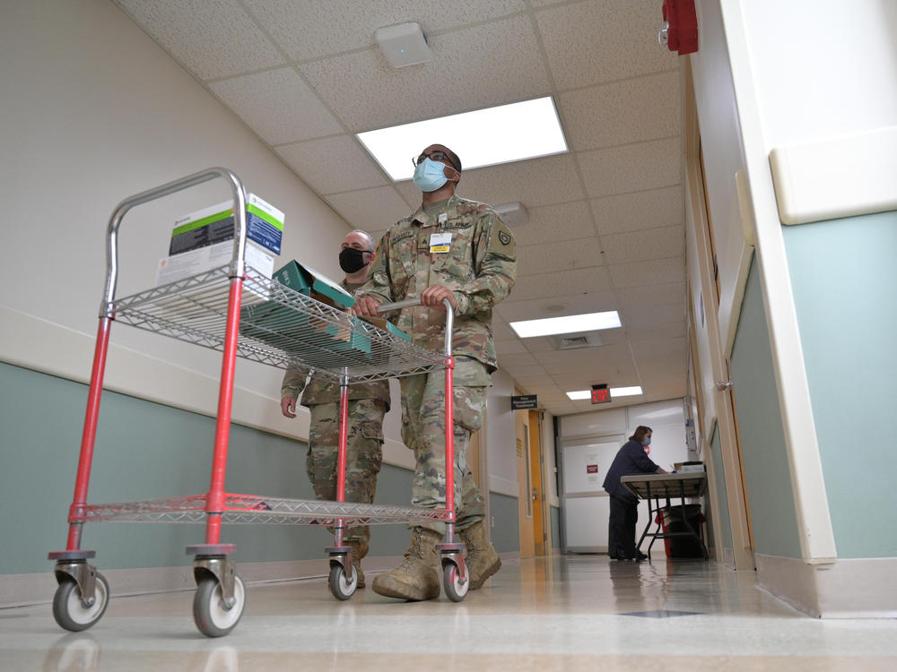 Sgt. Darrin Cushard (left) and Sgt. Dennis McClarity walk with a cart of PPE supplies in St. Claire Regional Medical Center in Morehead, Ky.