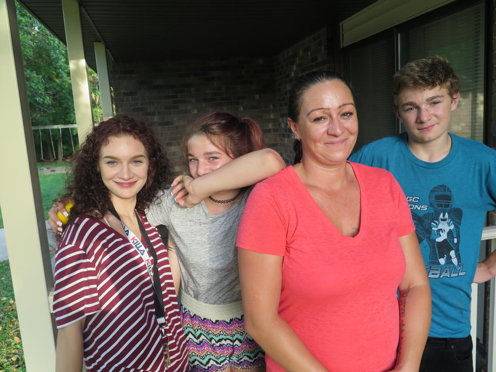 Daisy Hohman stands with her three children. She says the last bill she got from Wright County says she still owes more than $7,000 for foster care.