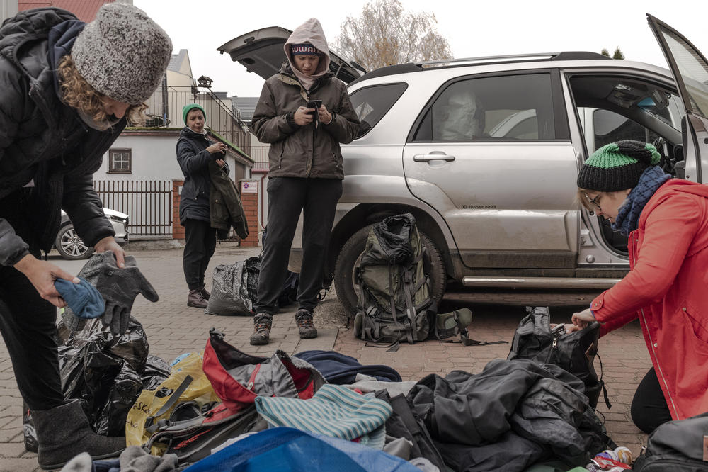 Activists from the Ocalenie Foundation prepare their car for an intervention, by packing clothes, food, water and power banks for charging cellphones, among other supplies.