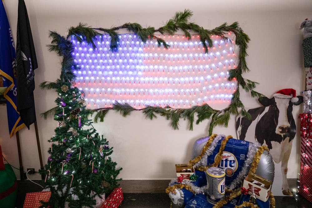 Republican Rep. Mike Gallagher of Wisconsin has a display featuring an American flag made out of twinkle lights, an inflatable Miller Lite chair and a cutout of a cow wearing a Santa hat.