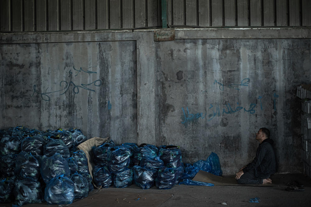 A Palestinian worker prays near vegetables ready to be exported to the West Bank. The farmers are focused on a rare opportunity to boost their income after years of export bans.