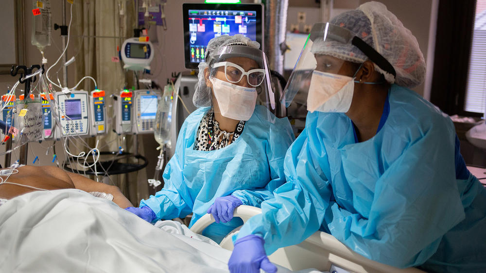 Dr. Denise Sese (left) discusses a patient's plan of care with nurse Ericka Tollerson in the COVID intensive care unit.