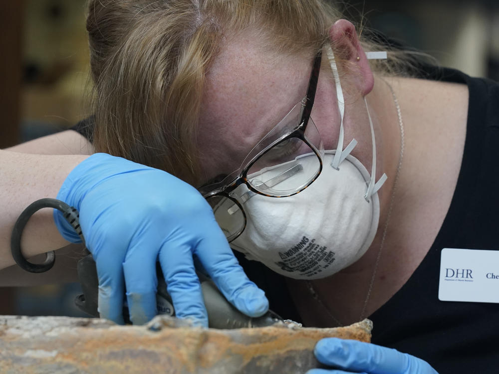 Conservator for the Virginia Department of Historic Resources, Chelsea Blake, works to open a time capsule. It took several hours for the experts to unseal the lead box.