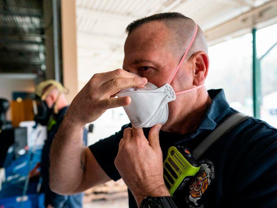 A firefighter tests the seal on his N95 mask at the start of his shift in Glen Burnie, Md. With the spread of omicron, experts say to wear high-filtration respirators in public indoor spaces for the best protection.