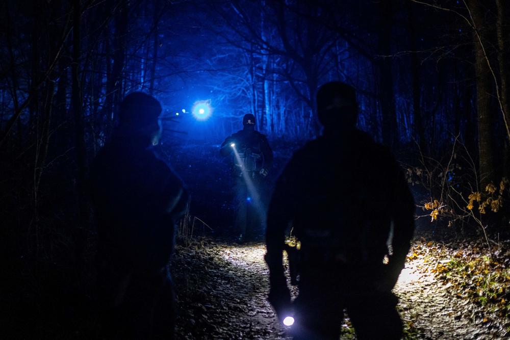 Police officers stand in the forest near Hajnowka, Poland, on Nov. 11. Western governments have accused Belarus' President Alexander Lukashenko of luring migrants, mainly from the Middle East, to his country and sending them to cross over into EU member Poland.