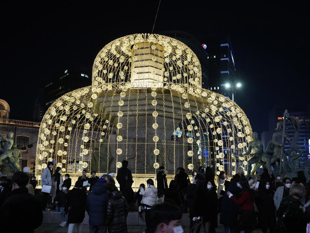 People gather around illuminated Christmas decorations on Christmas Eve in Seoul, South Korea.