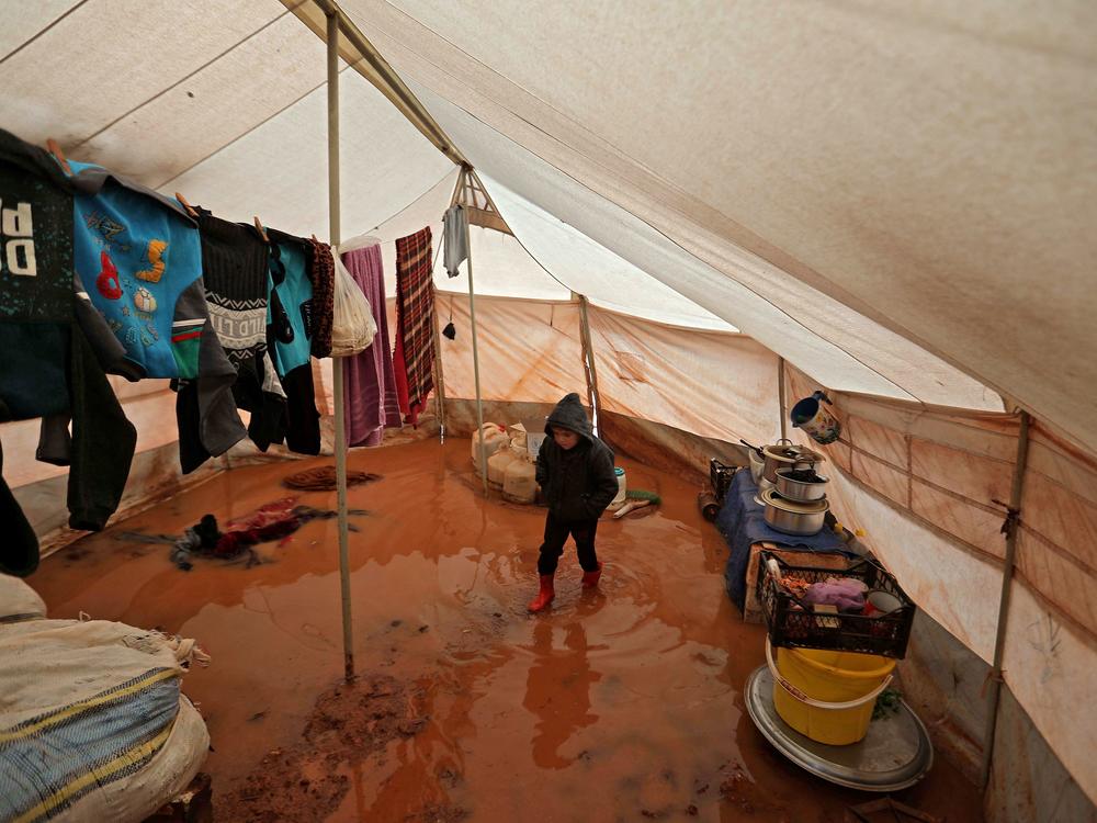 A child walks inside a flooded tent at a camp for the displaced people near Bab al-Hawa by the border with Turkey, in Syria's northwestern Idlib province, on Monday.