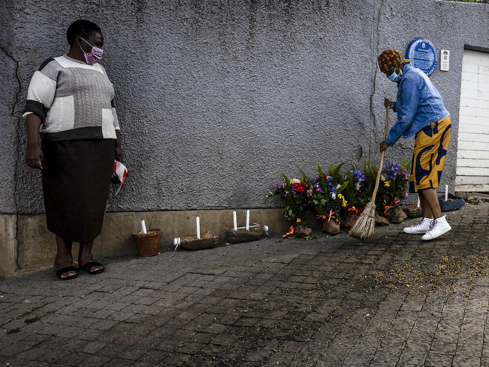 A woman sweeps outside the house where Desmond Tutu lived in Soweto, South Africa. Tutu, South Africa's Nobel Peace Prize-winning activist for racial justice and LGBT rights and retired Anglican Archbishop of Cape Town, has died.