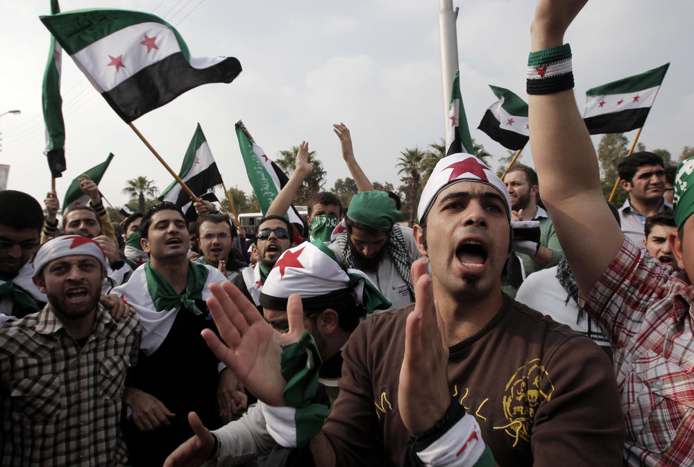 Pro-reform supporters, waving Syria's pre-Baath old national flag, protest outside the Arab League headquarters in the Egyptian capital Cairo, where a ministerial meeting on Syria was held on Nov. 24, 2011. The Arab Spring protests of that year drew many activists, advocates and journalists to the region.