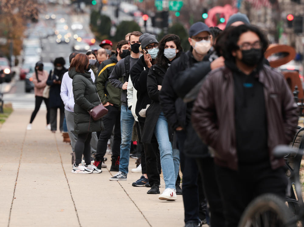 People wait in line at a testing site to receive a free COVID-19 PCR test in Washington, D.C. On Monday, the CDC announced that people can isolate for five days, instead of 10, after they've tested positive for the coronavirus and have no symptoms.