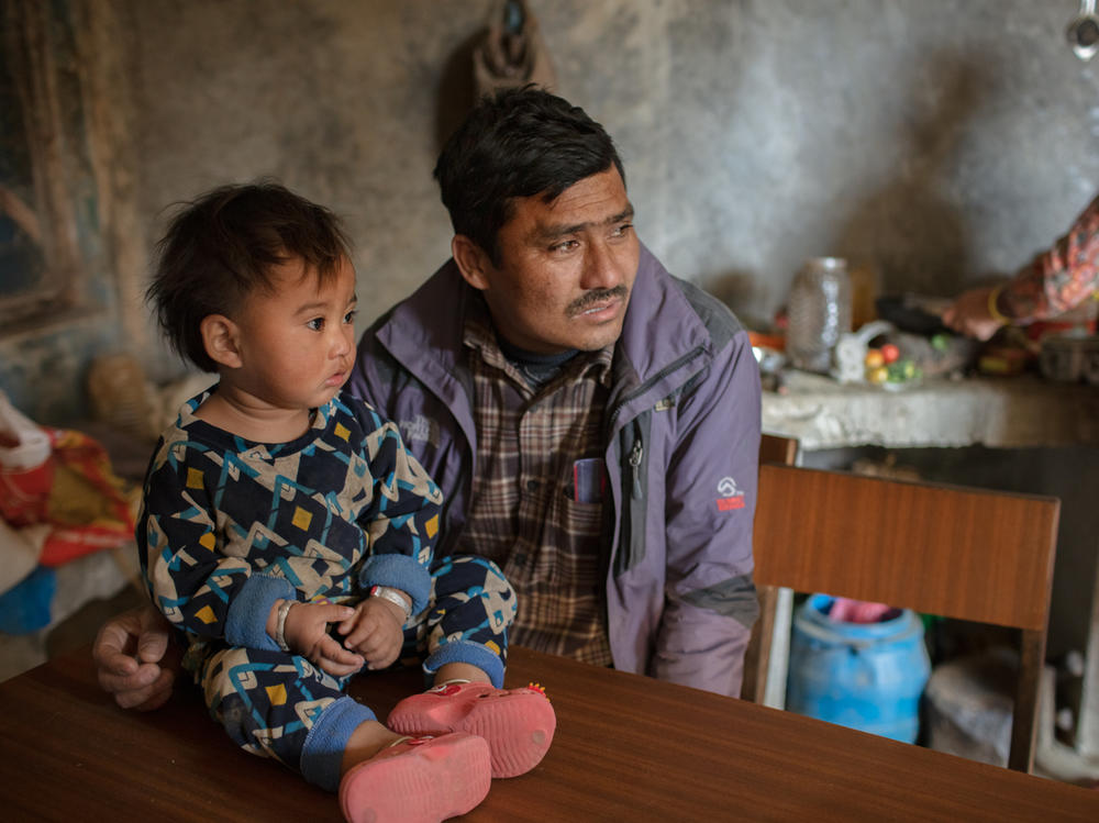 Married at 15, Chakraman Shreshta Balami fulfilled his dying father's wish by getting married — at age 15. He had to give up his dream of becoming a doctor. Now the vice principal of Sri Bhavani government school, he campaigns against child marriage — but even his son was married as a teenager. Above, he poses with a grandchild.