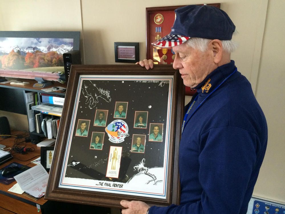 Allan McDonald in 2016 with a commemorative poster honoring the seven astronauts killed aboard the space shuttle Challenger.