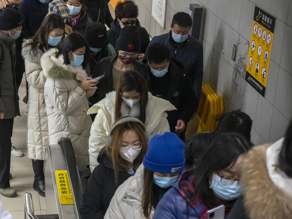 Commuters wearing face masks  ride an escalator at a subway station in the central business district in Beijing. Caseloads of omicron have remained relatively low in many parts in Asia.