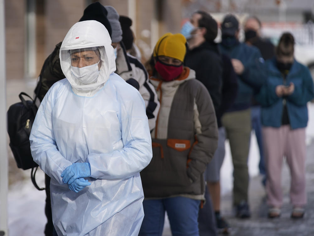 A member of the Salt Lake County Health Department COVID-19 testing staff walks past a line outside the department on Tuesday. The number of new COVID019 cases hit a record this week, topping numbers from January.