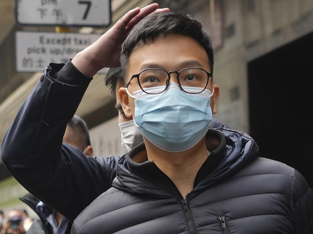 Patrick Lam, an editor at Stand News, is escorted into a van by police officers after they searched for evidence at his office in Hong Kong, Wednesday, Dec. 29, 2021.