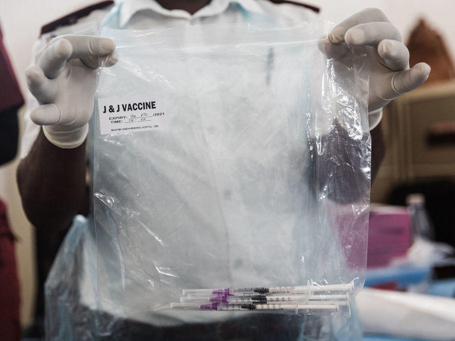 A health care worker holds doses of J&J vaccines at the Gandhi Phoenix Settlement in Bhambayi township, South Africa, on Sept. 24. A study of the J&J booster shot in the country had promising results against the omicron variant.