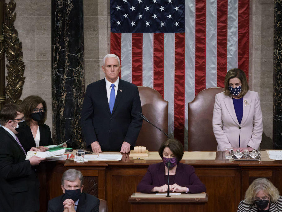 Vice President Mike Pence and Speaker of the House Nancy Pelosi, D-Calif., read the final certification of Electoral College votes cast in November's presidential election, hours after a pro-Trump mob broke into the U.S. Capitol.