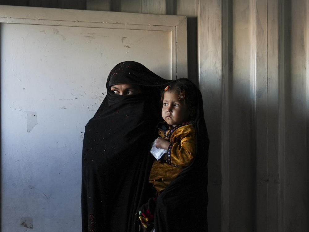 An Afghan woman waits in the makeshift clinic organized by World Vision at a settlement near Herat, Afghanistan.