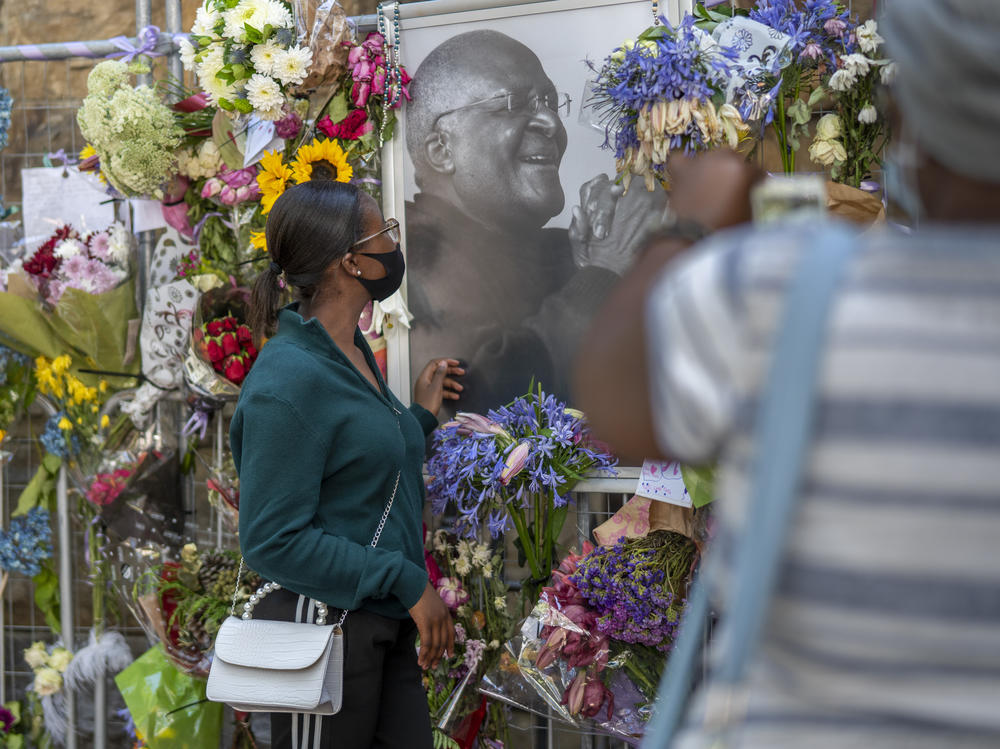People read cards left with flowers in memory of Anglican Archbishop Emeritus Desmond Tutu at the St. George's Cathedral.