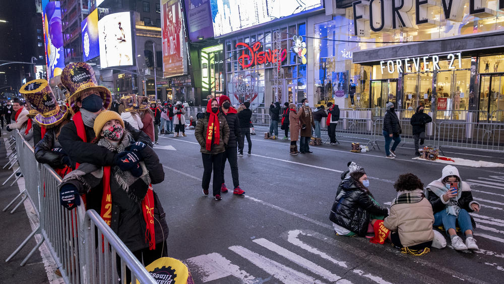 Revelers, in small groups in some areas, gather on Times Square on Friday.