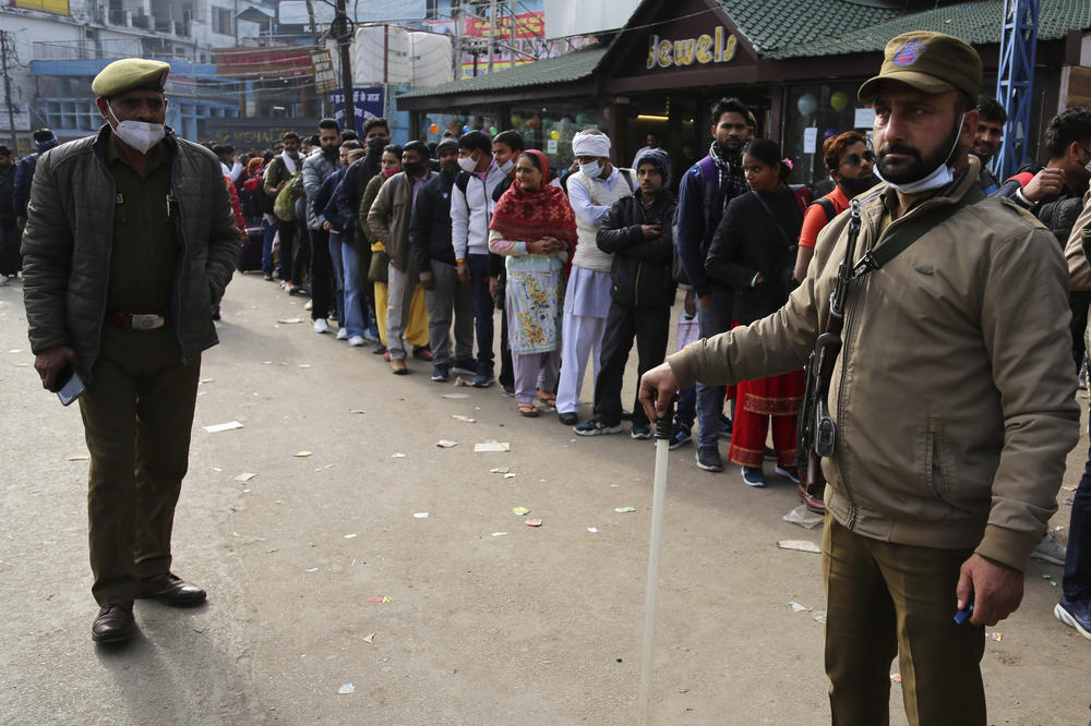 Policemen stand guard as devotees line up for registration to visit the holy cave of Mata Vaishnav Devi shrine following a stampede on Saturday.