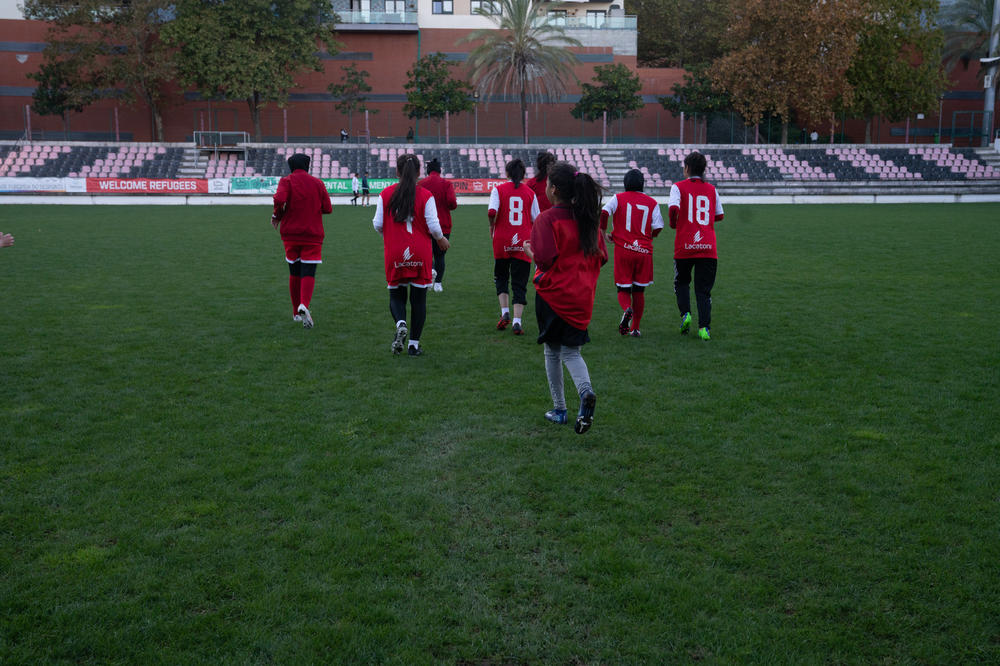 The girls cool down after practice as dusk falls on the field.