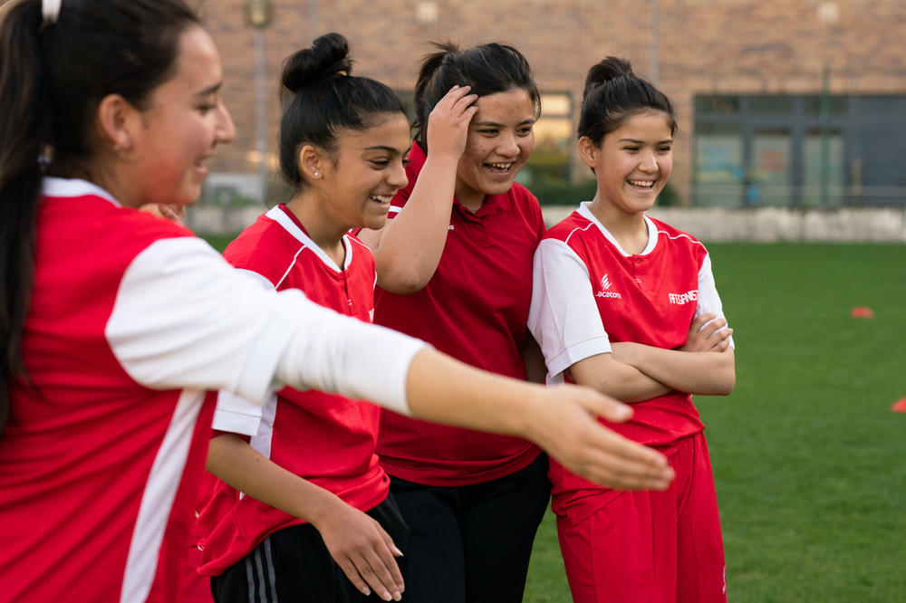 Girls laugh as they are divided into teams for a practice scrimmage.