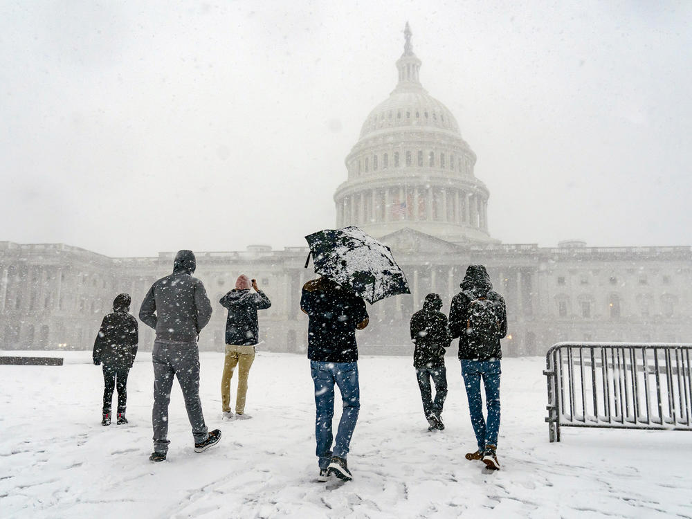 Visitors from France enjoy the scenery as a winter storm delivers heavy snow to the Capitol in Washington, D.C., on Monday.