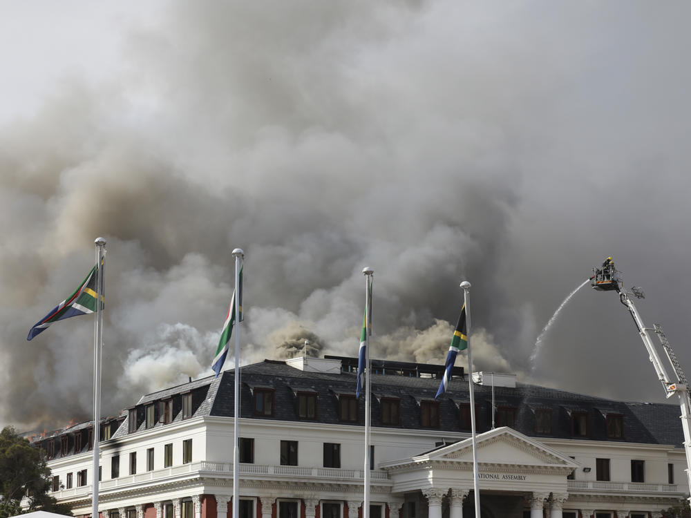 Smoke rises from the Parliament in Cape Town, South Africa, on Monday, Jan 3, 2022 after the fire re-ignited late afternoon. Firefighters are again on the scene after a major blaze tore through the precinct a day earlier.