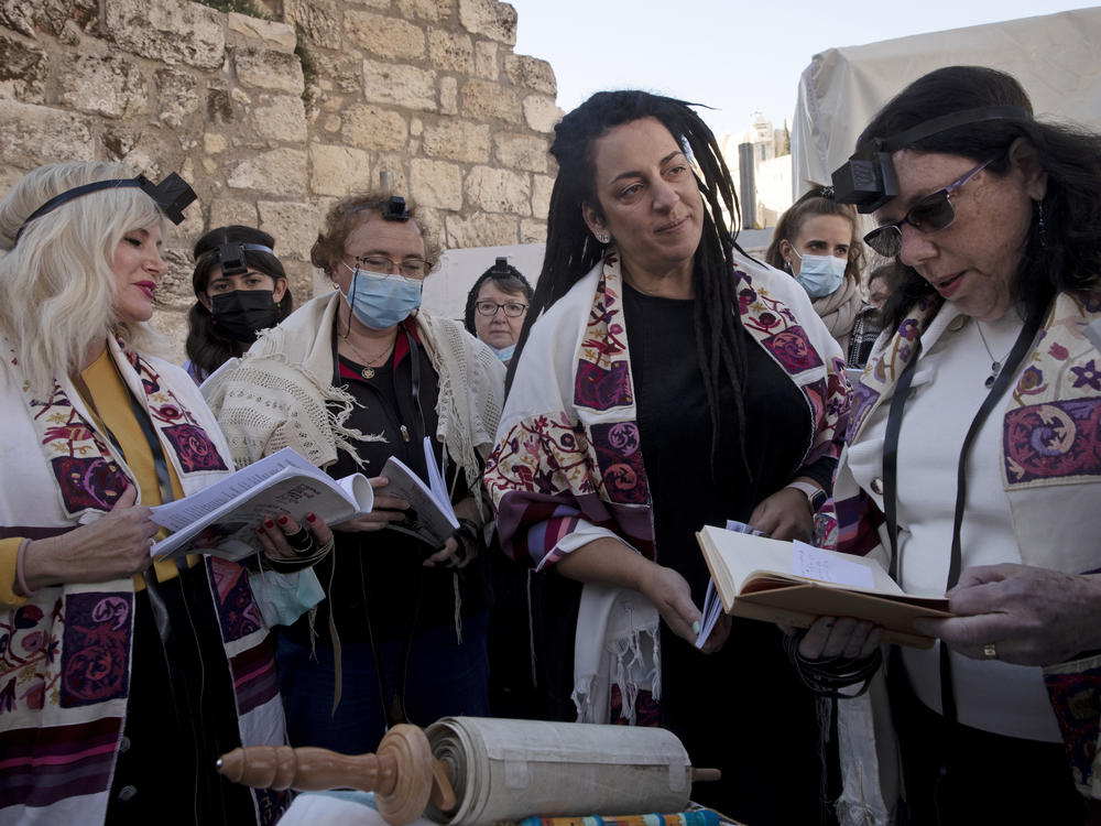 Members of Women of the Wall gather around a Torah scroll the group smuggled in for their Rosh Hodesh prayers marking the new month, at the Western Wall where women are forbidden from reading from the Tora.