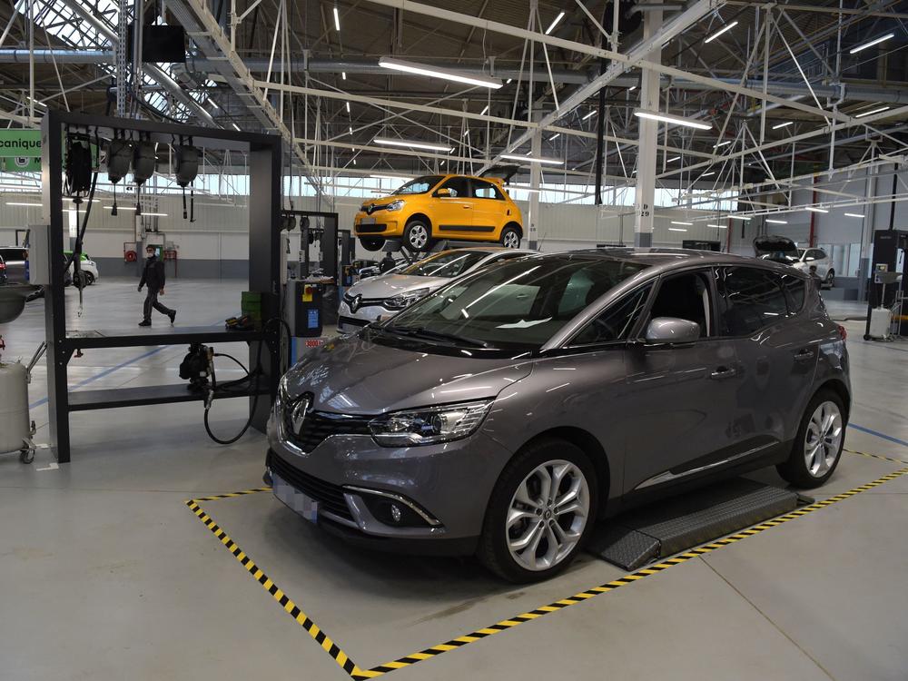 An employee walks among the cars during the inauguration of a factory that will recondition used cars near Paris, on Nov. 30.