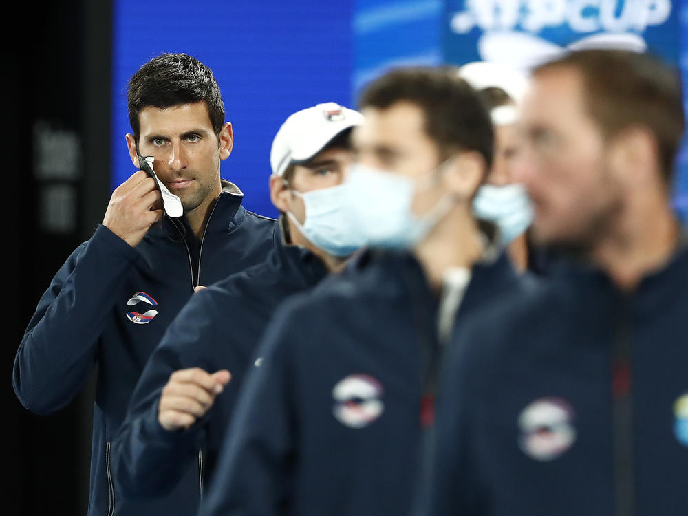 Novak Djokovic will play in the 2022 Australian Open, after getting an exemption from vaccine requirements. He's seen here removing his mask at the 2021 ATP Cup at Rod Laver Arena in Melbourne last February.