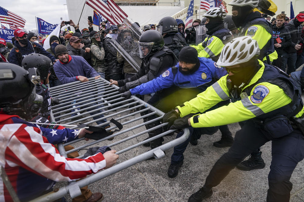 Supporters of then-President Donald Trump try to break through a police barrier at the Capitol in Washington. They would ultimately succeed.