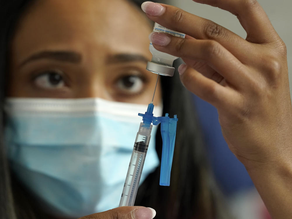 Licensed practical nurse Yokasta Castro, of Warwick, R.I., draws a Moderna COVID-19 vaccine into a syringe. The vaccines have now been linked to minor changes in menstruation, but are still considered safe.