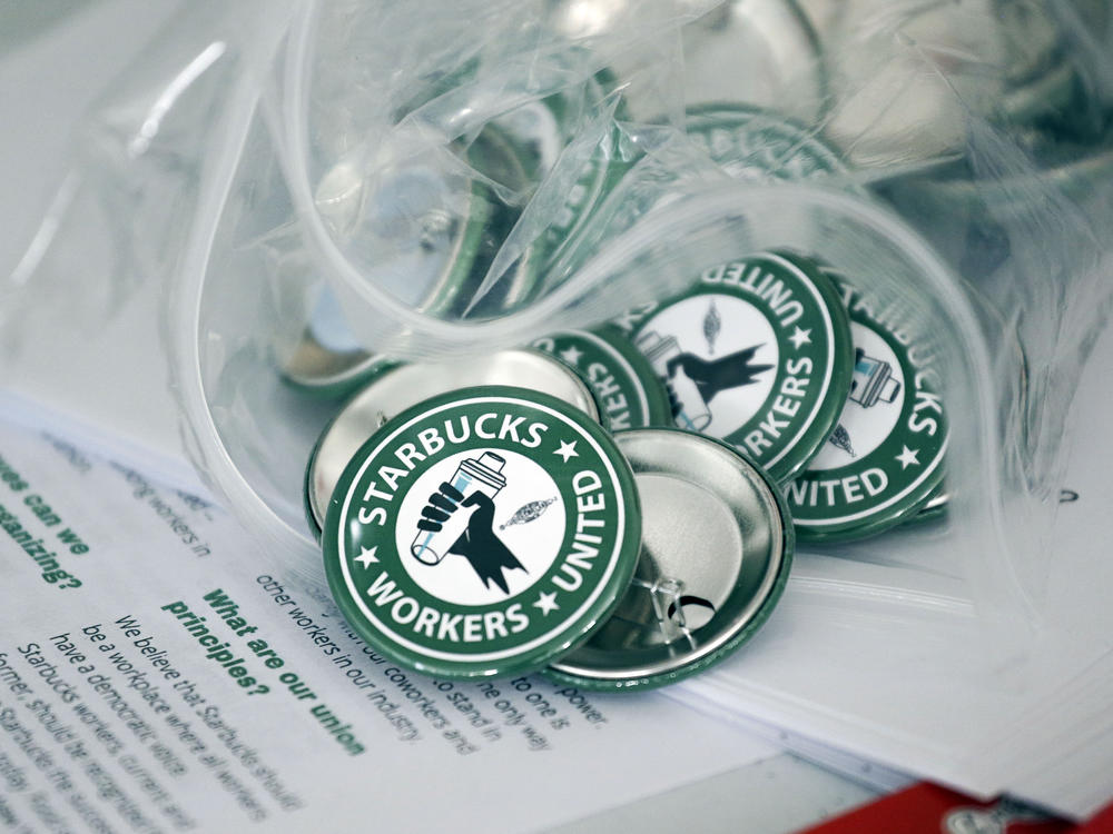 Pro-union pins sit on a table during a watch party for a Starbucks employees union election on Dec. 9 in Buffalo, N.Y.