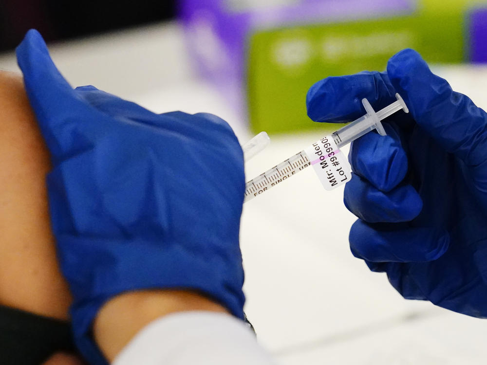 A health worker administers a dose of a Moderna COVID-19 vaccine during a vaccination clinic at the Norristown Public Health Center in Norristown, Pa., Tuesday, Dec. 7, 2021.