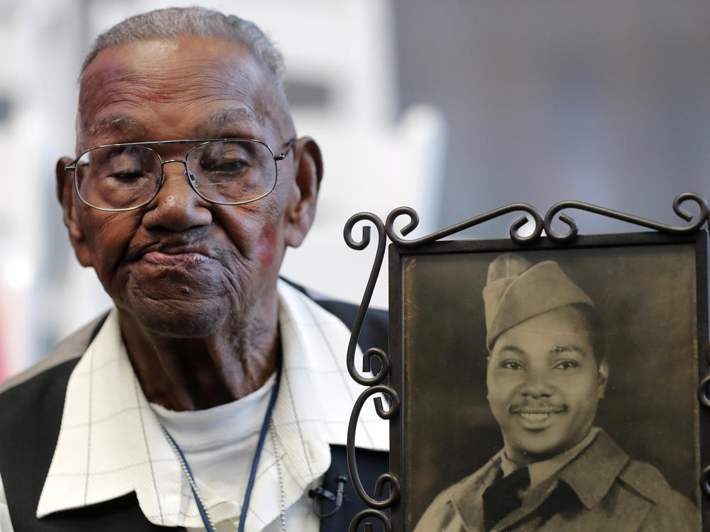 World War II veteran Lawrence Brooks, pictured holding a photo of himself as a soldier in 1943, died on Wednesday at age 112.