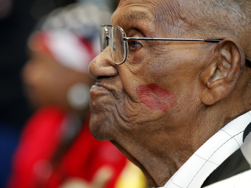 Lawrence Brooks, pictured in 2019, sports a lipstick kiss on his cheek, planted by a member of the singing group Victory Belles.