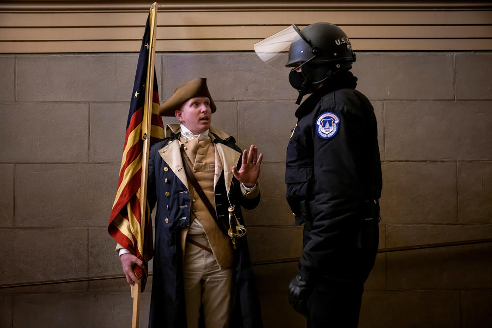 A protester dressed as George Washington debates with a Capitol Police officer before being pushed out.