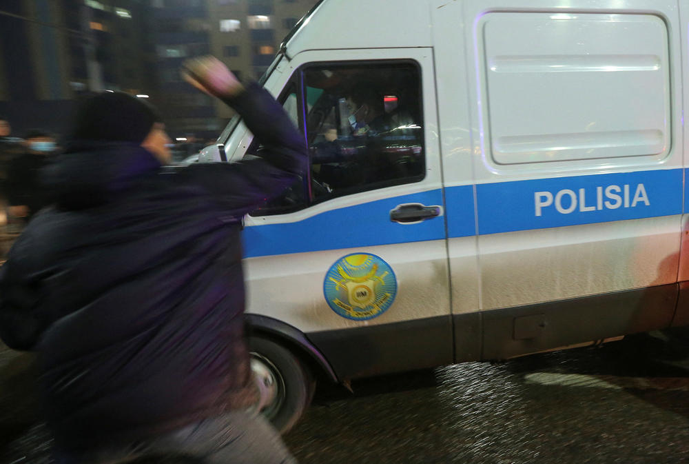 A man attacks a police minivan during protests on Tuesday that followed sudden price hikes of liquefied petroleum gas.