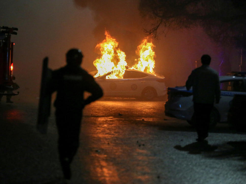 A police car on fire during a protest in Almaty on Wednesday.