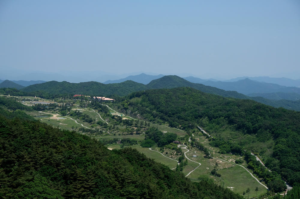 A THAAD missile defense battery (at left) sits facing north, on a former golf course in Seongju county, South Korea. U.S. and South Korean soldiers have reportedly been living in an old clubhouse (to the right of the batteries) and shipping containers.