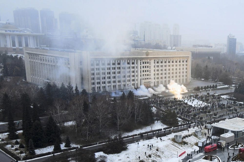 Smoke rises from the city hall building during a protest in Almaty, Kazakhstan, Wednesday. Kazakh news site Zakon said many of the demonstrators who converged on the building carried clubs and shields.