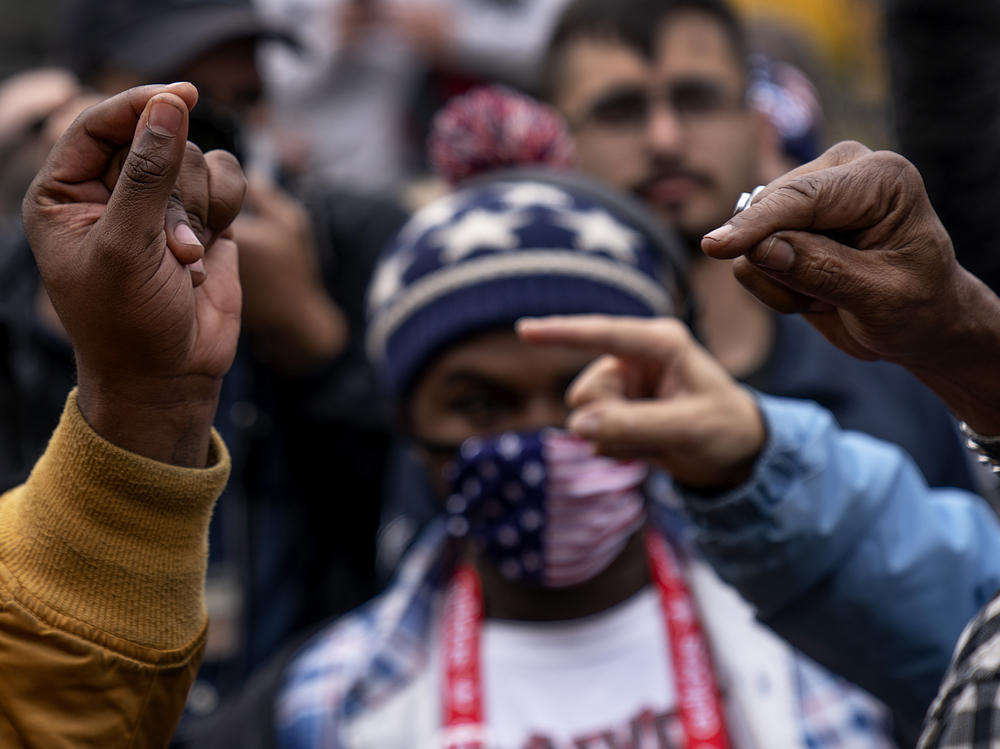 Biden and Trump supporters gesture at one another as they argue while Trump supporters demonstrate against the election results in Detroit on Nov. 5, 2020.