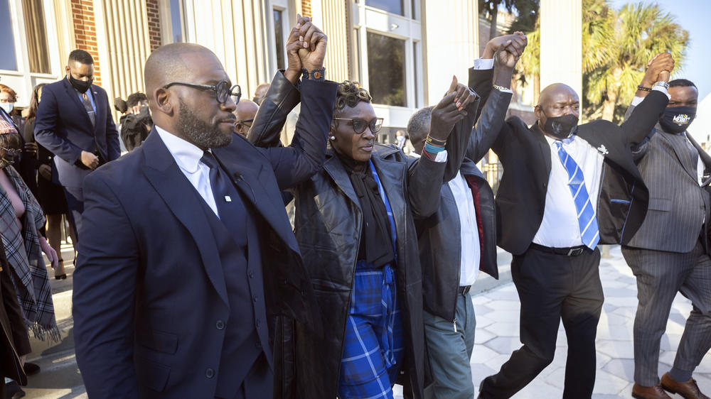 Ahmaud Arbery's mother, Wanda Cooper-Jones, center, walks out of the Glynn County Courthouse surrounded by supporters after a judge sentenced Greg McMichael, his son, Travis McMichael, and a neighbor, William 