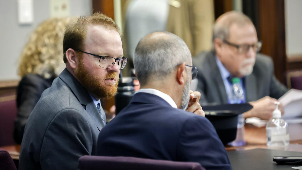 Travis McMichael, left, speaks with his attorney Jason B. Sheffield, center, during his sentencing on Friday. McMichael and father Greg McMichael and neighbor William 