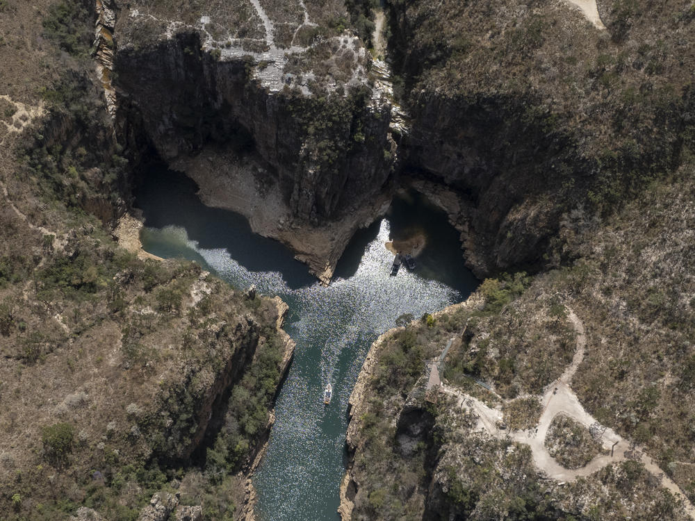 A tourist boat navigates through a canyon in Furnas Lake, near Capitolio City, Brazil on Sept. 2, 2021.